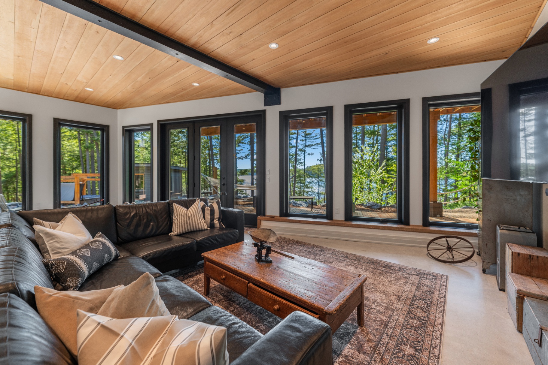 Lakeside lounge with leather sectional and walkout to the deck