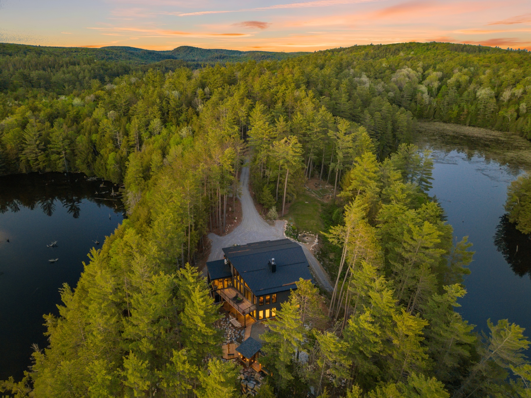 Wide overhead view of the property centered between two waterways at golden hour