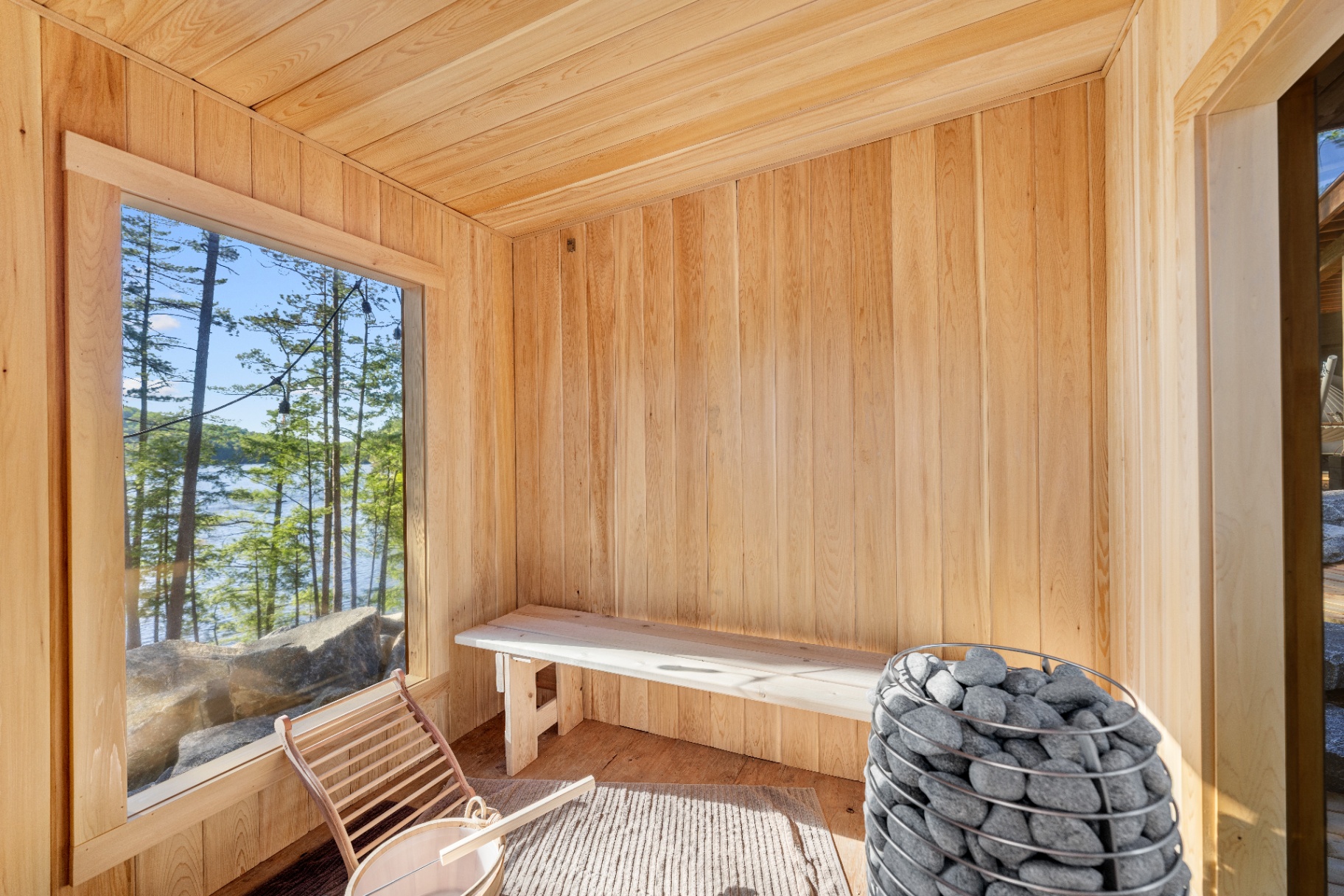 Cedar sauna interior with picture window overlooking the lake