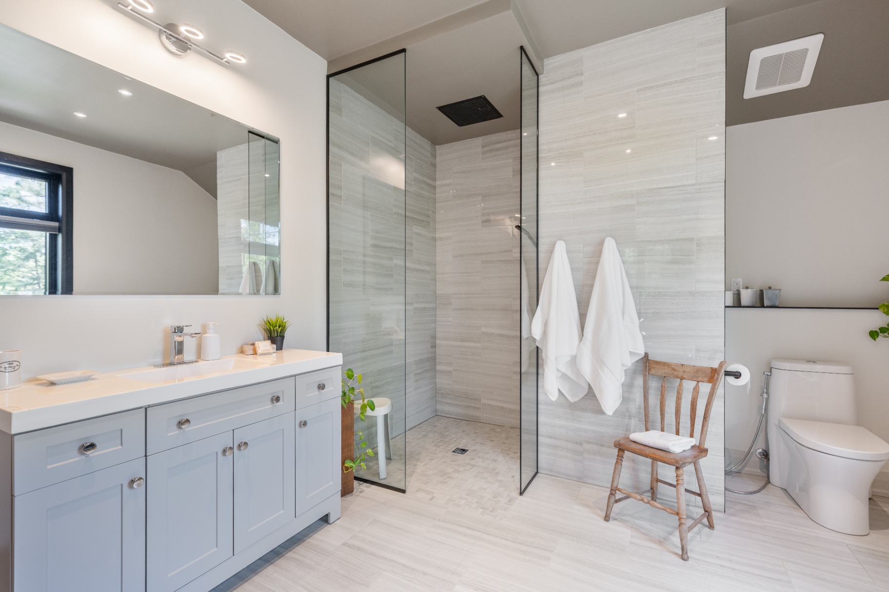Ensuite vanity and glass shower with soft stone finishes