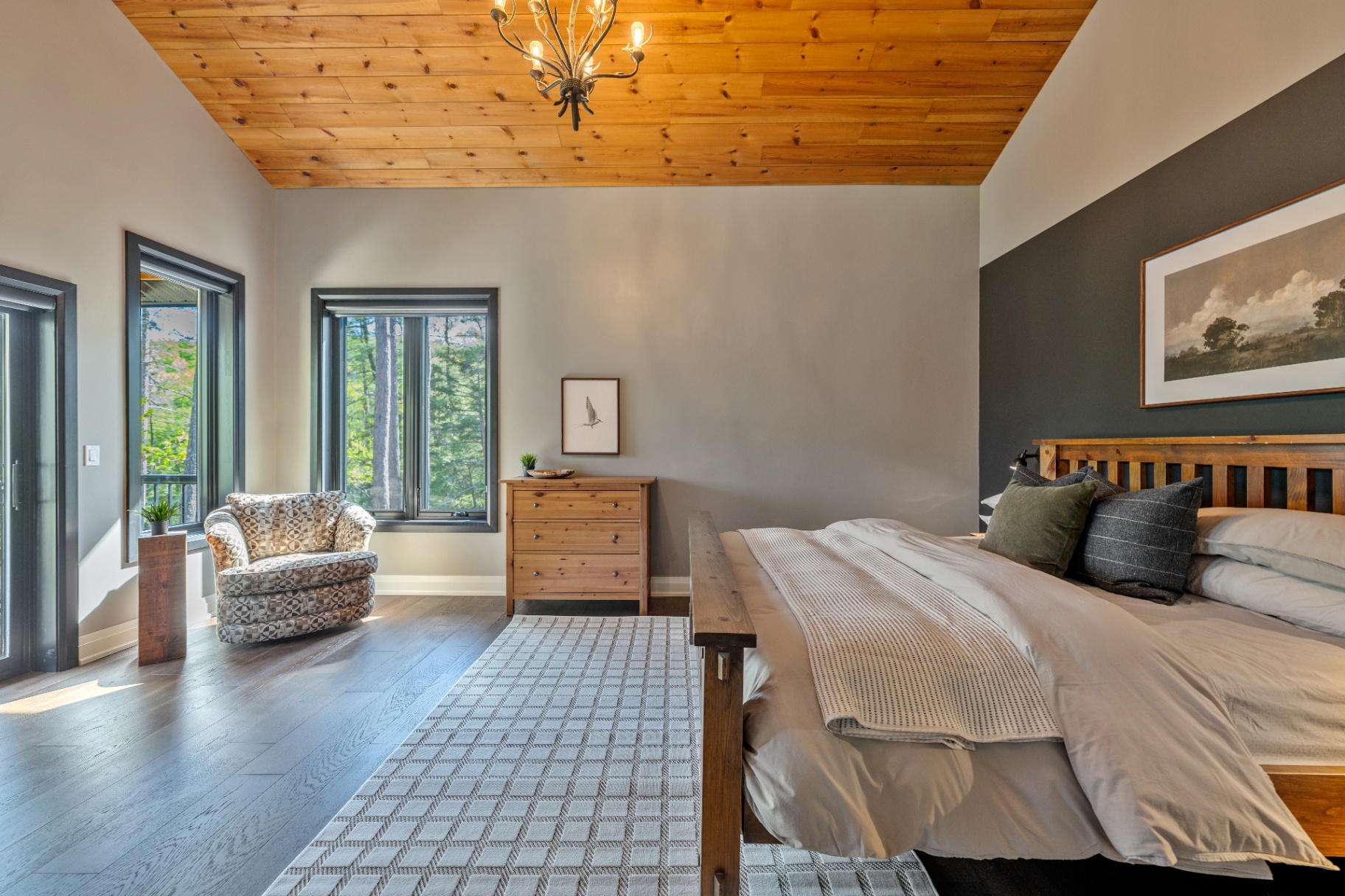 Primary bedroom with vaulted wood ceiling and reading chair