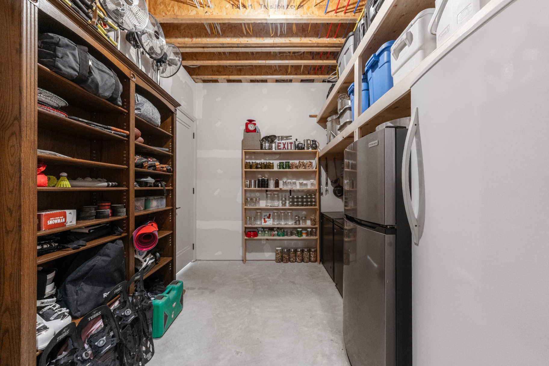 Organized utility and gear room with open shelving and mini fridge