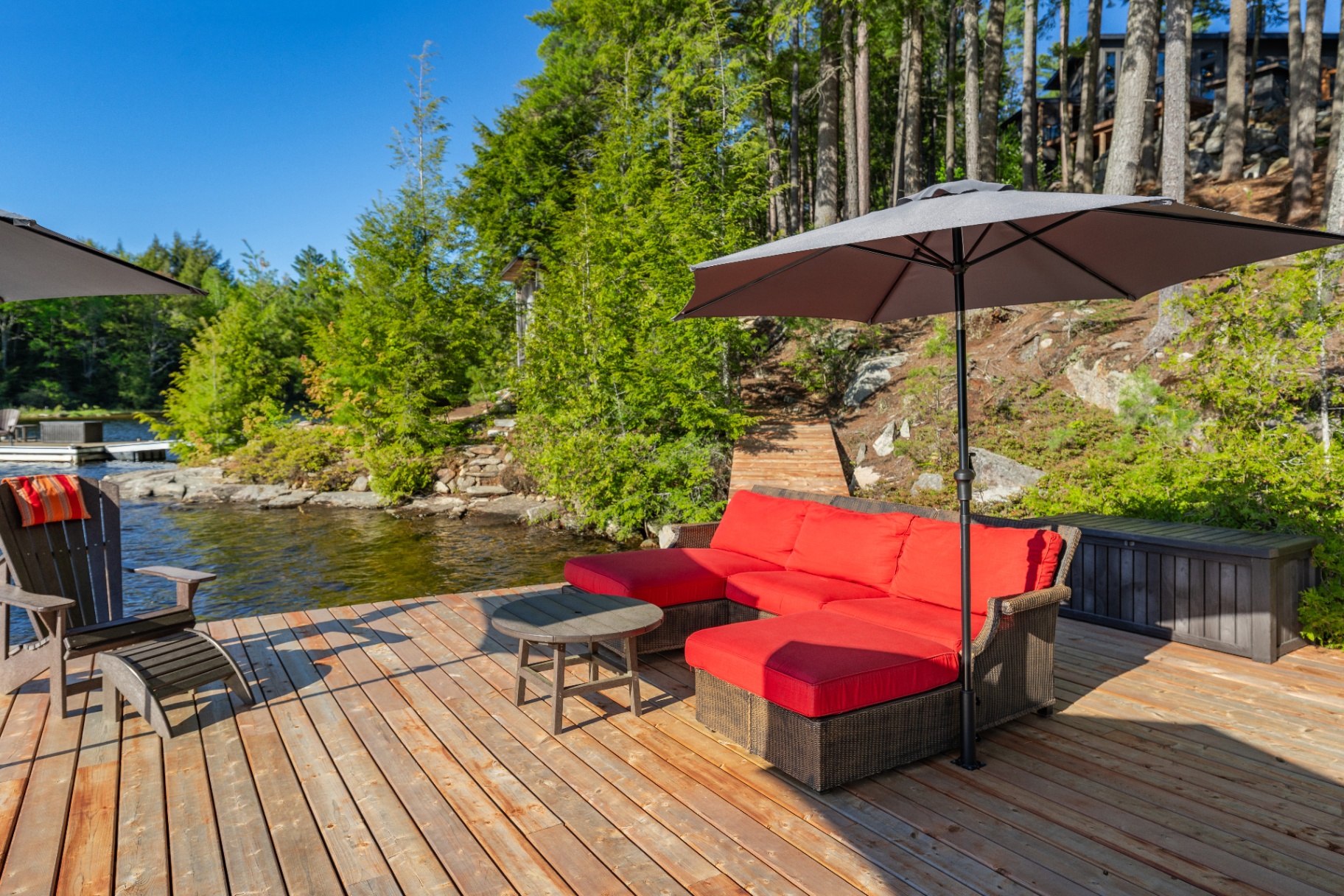 Lower dock lounge with red sectional looking back toward the house above