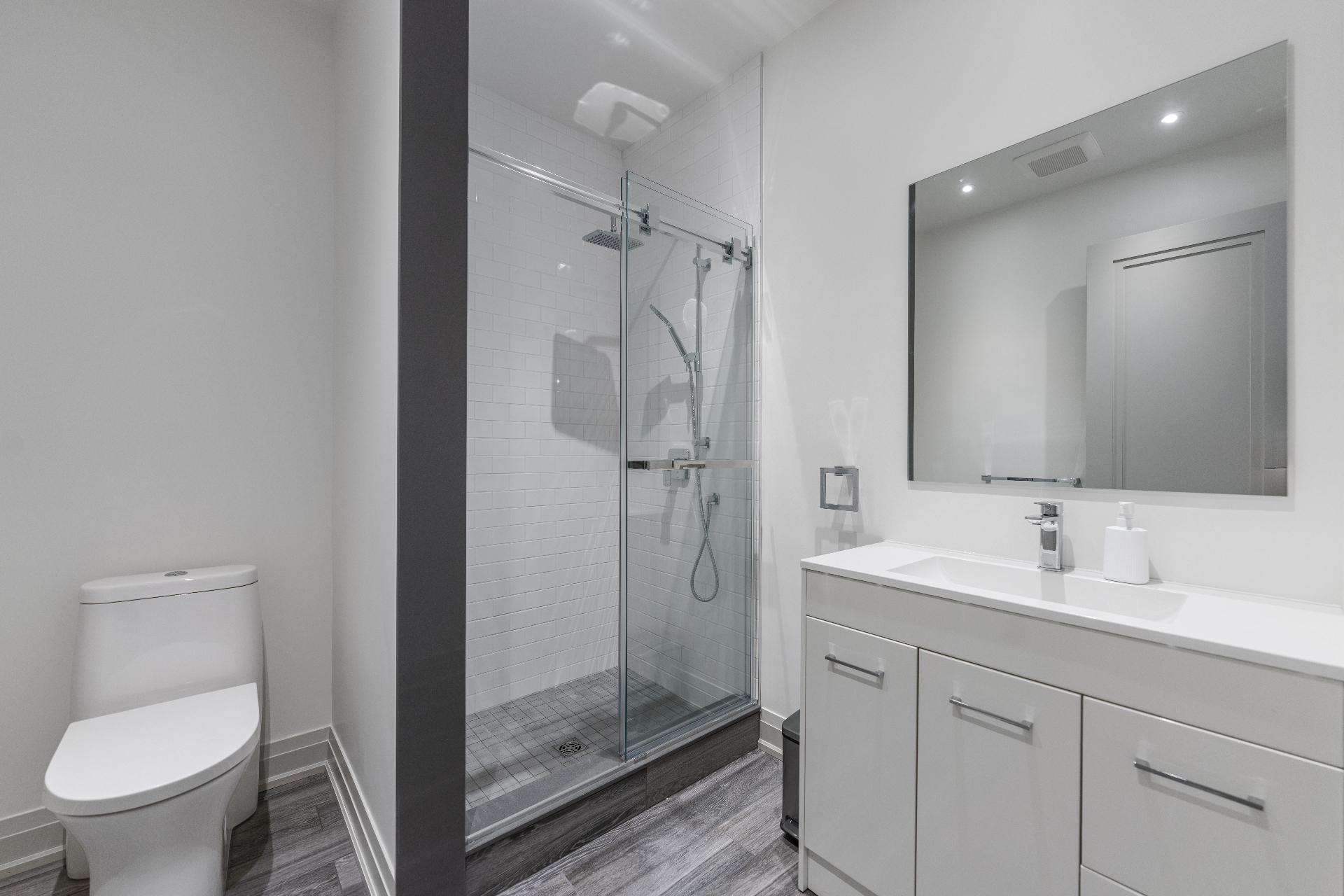 Lower-level bathroom with glass shower and modern vanity