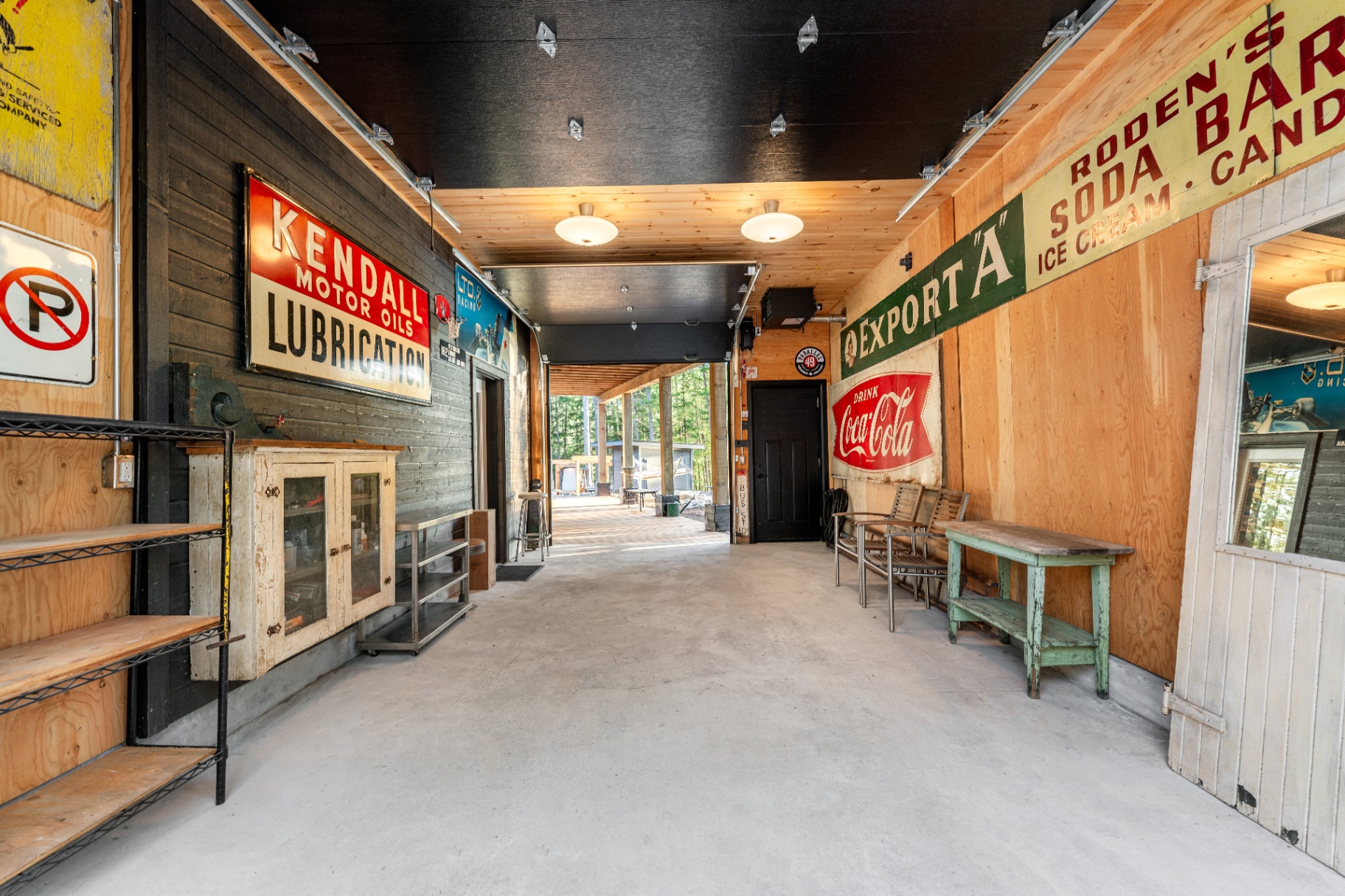 Covered breezeway lined with vintage Coca-Cola, Kendall, and Export A signs