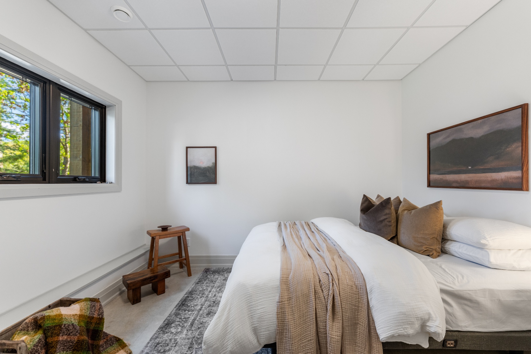 Lower-level guest bedroom with framed lakescape artwork