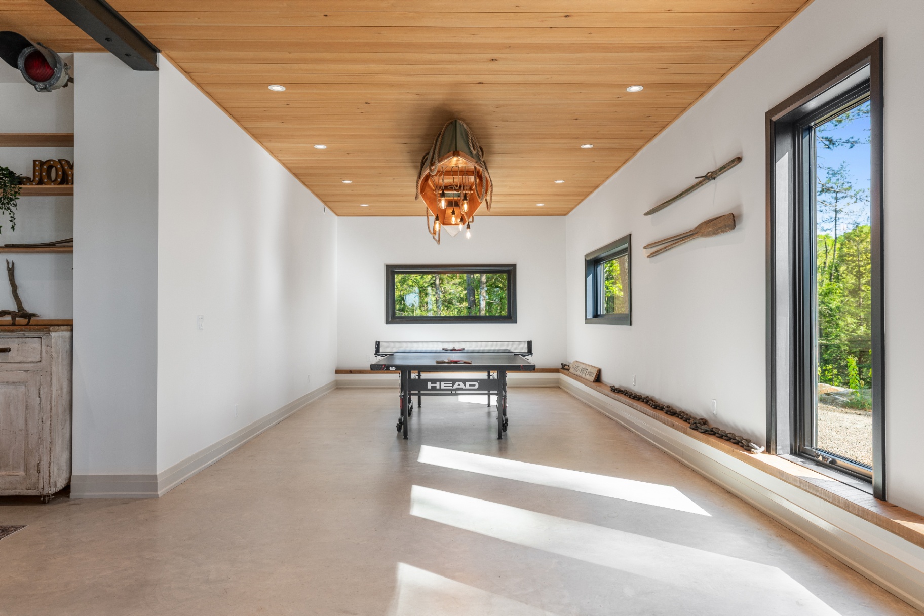 Ping-pong room with canoe pendant light and bench seating