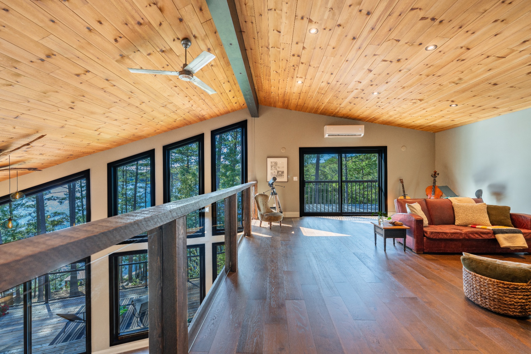 Upstairs loft lounge with pine ceiling and treetop views