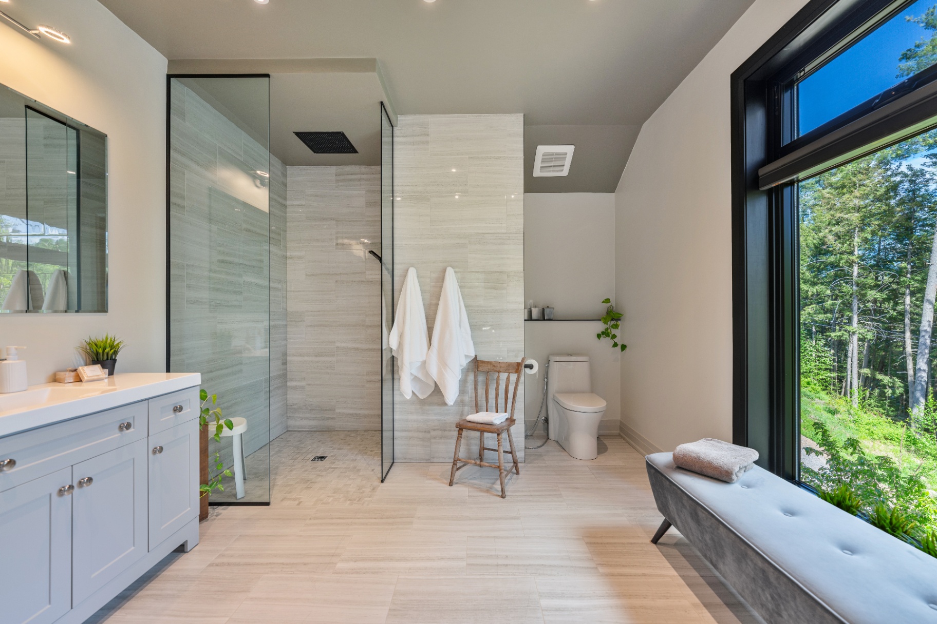 Spa-like ensuite bathroom with walk-in shower and forest view