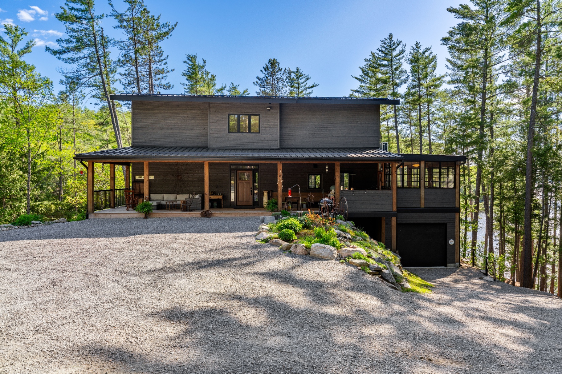 Exterior front of the lake house framed by pines