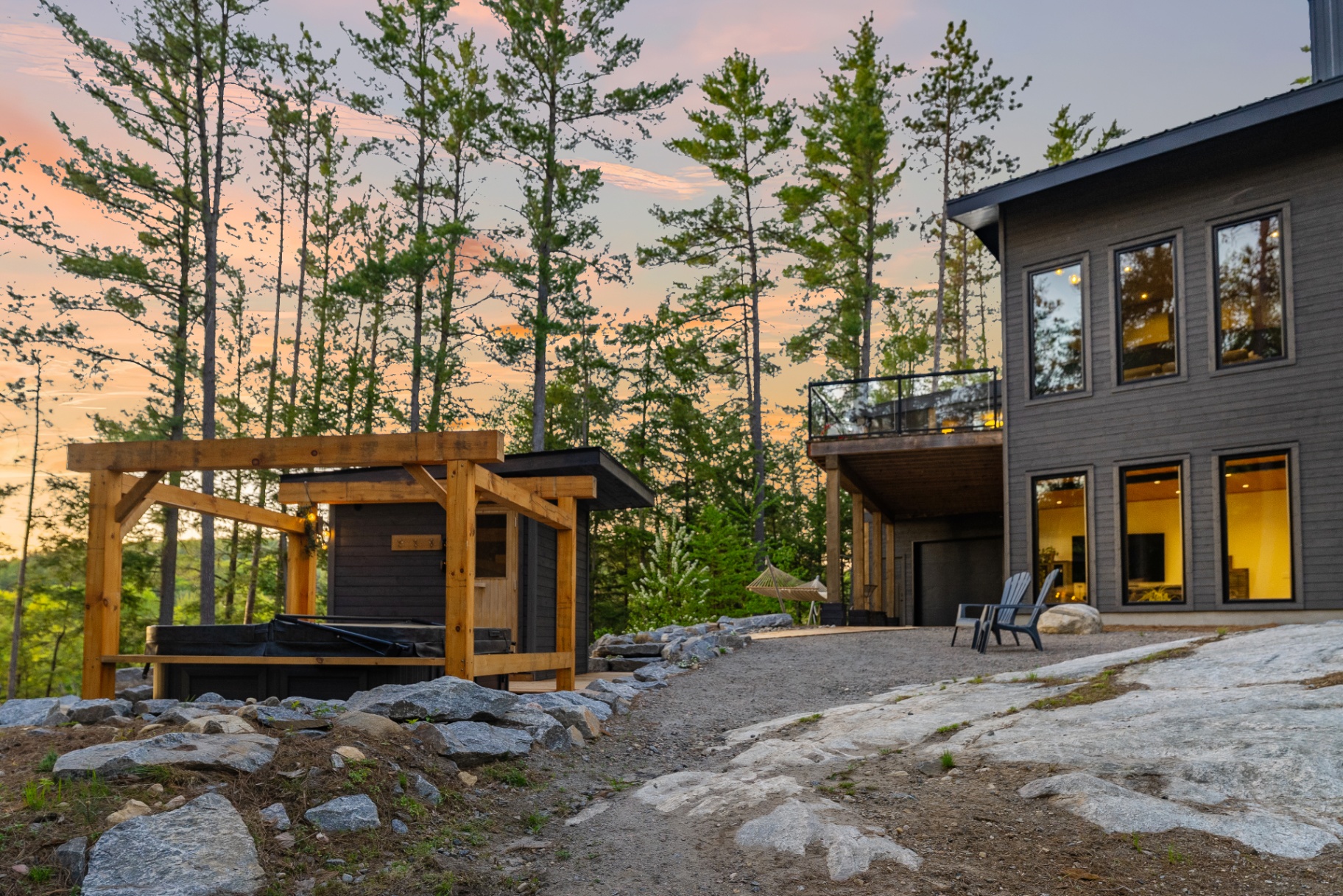 Sunset view of the hot tub terrace and rear exterior rising from the granite landscape