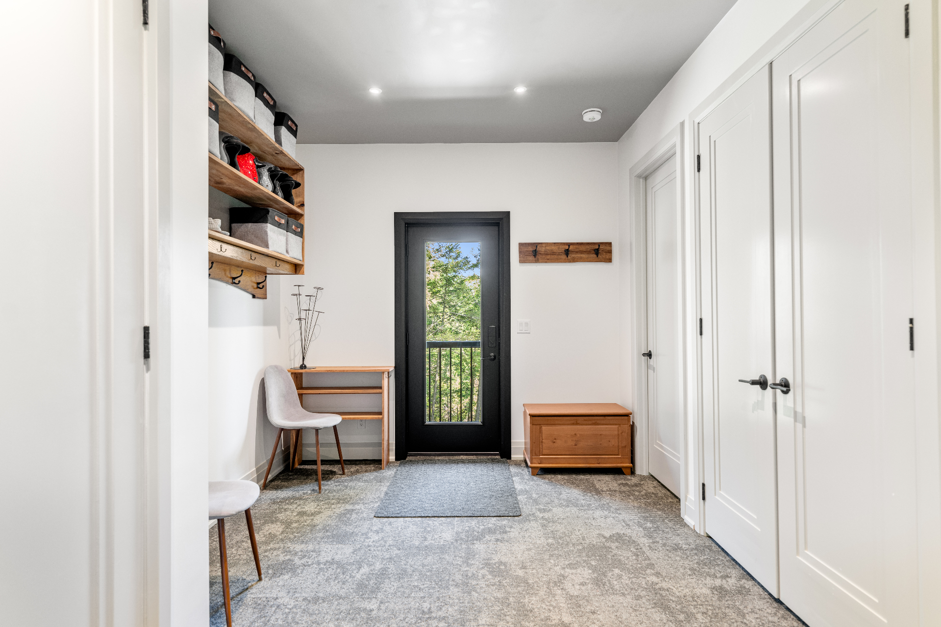 Mudroom with built-in shelving and rear door