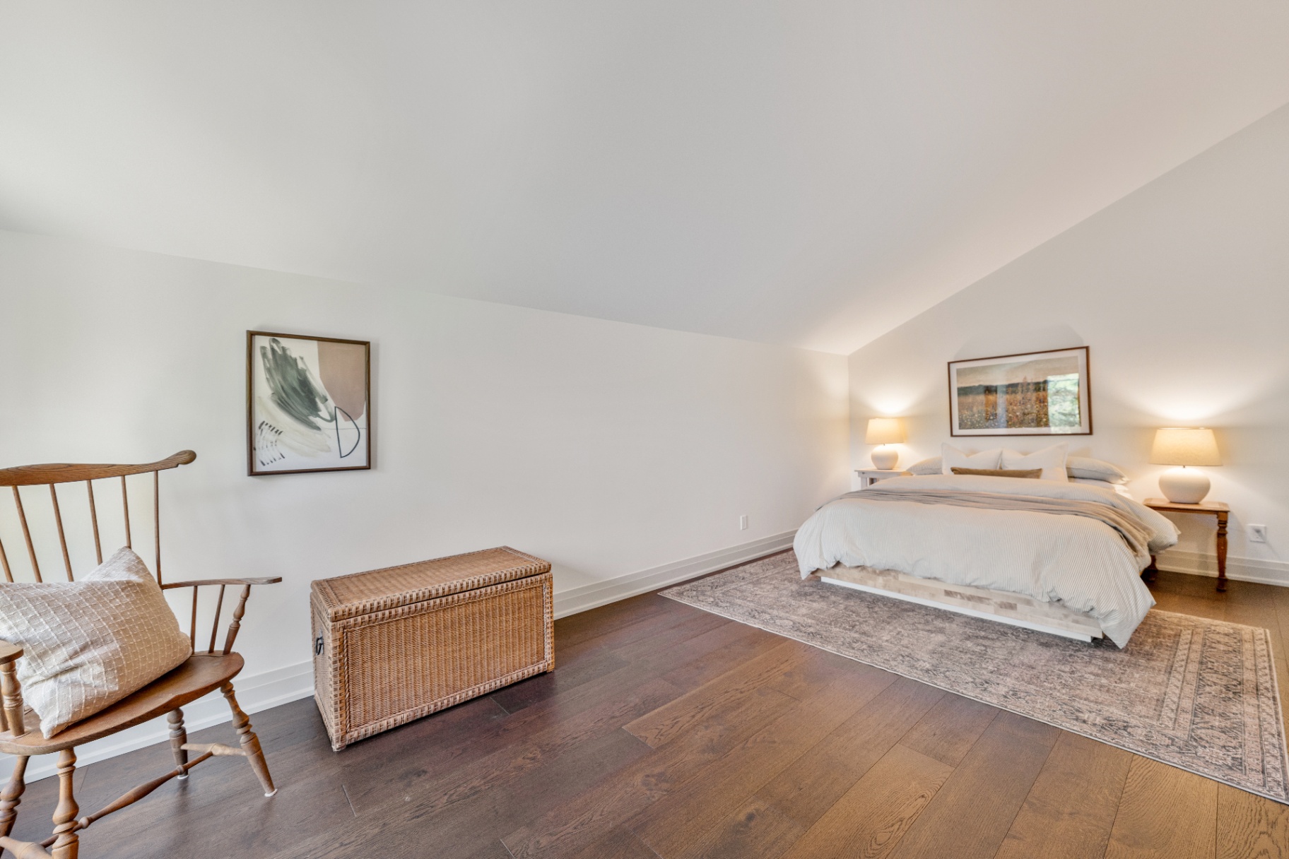 Upper bedroom with wide plank floors and low sloped ceiling