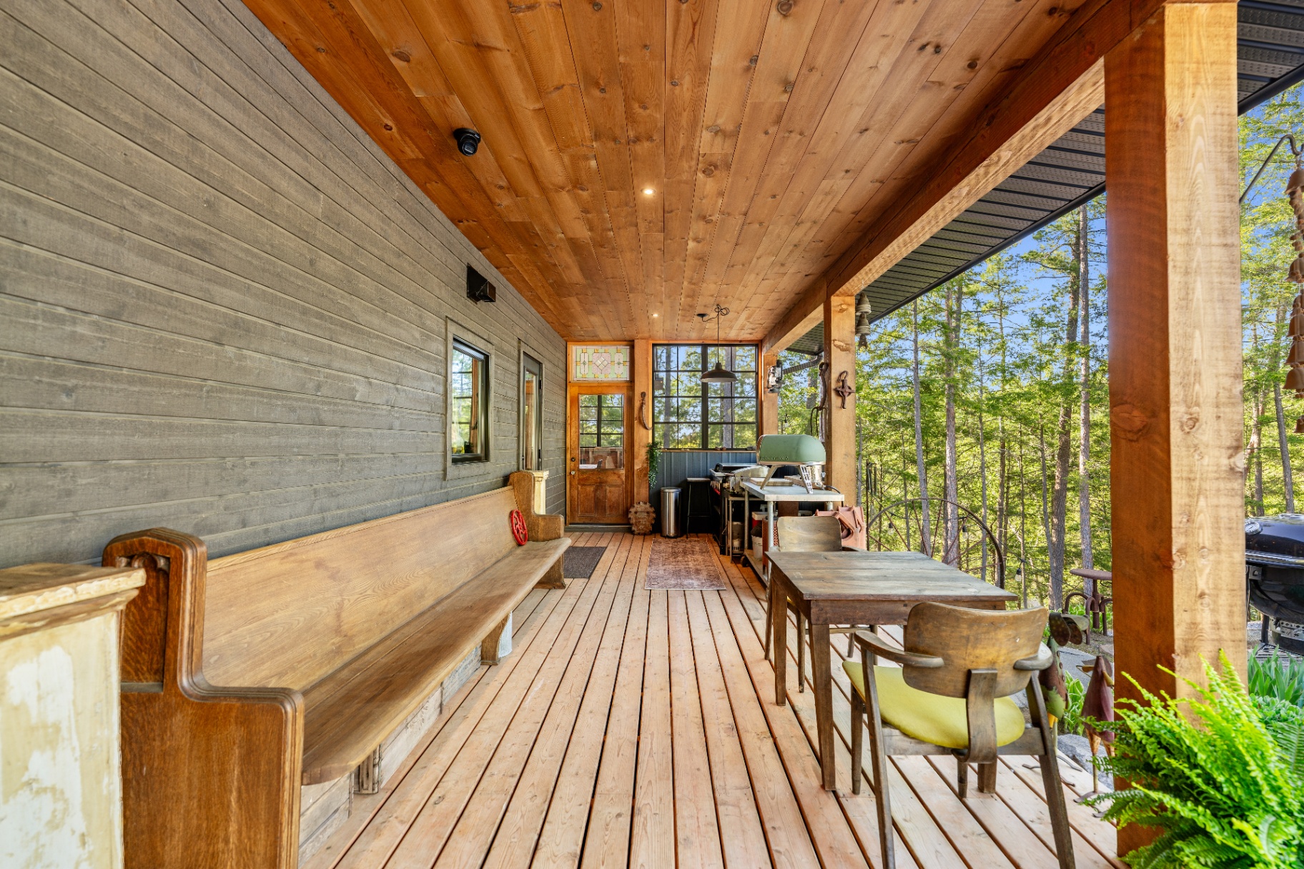Wraparound porch with pew bench and grill