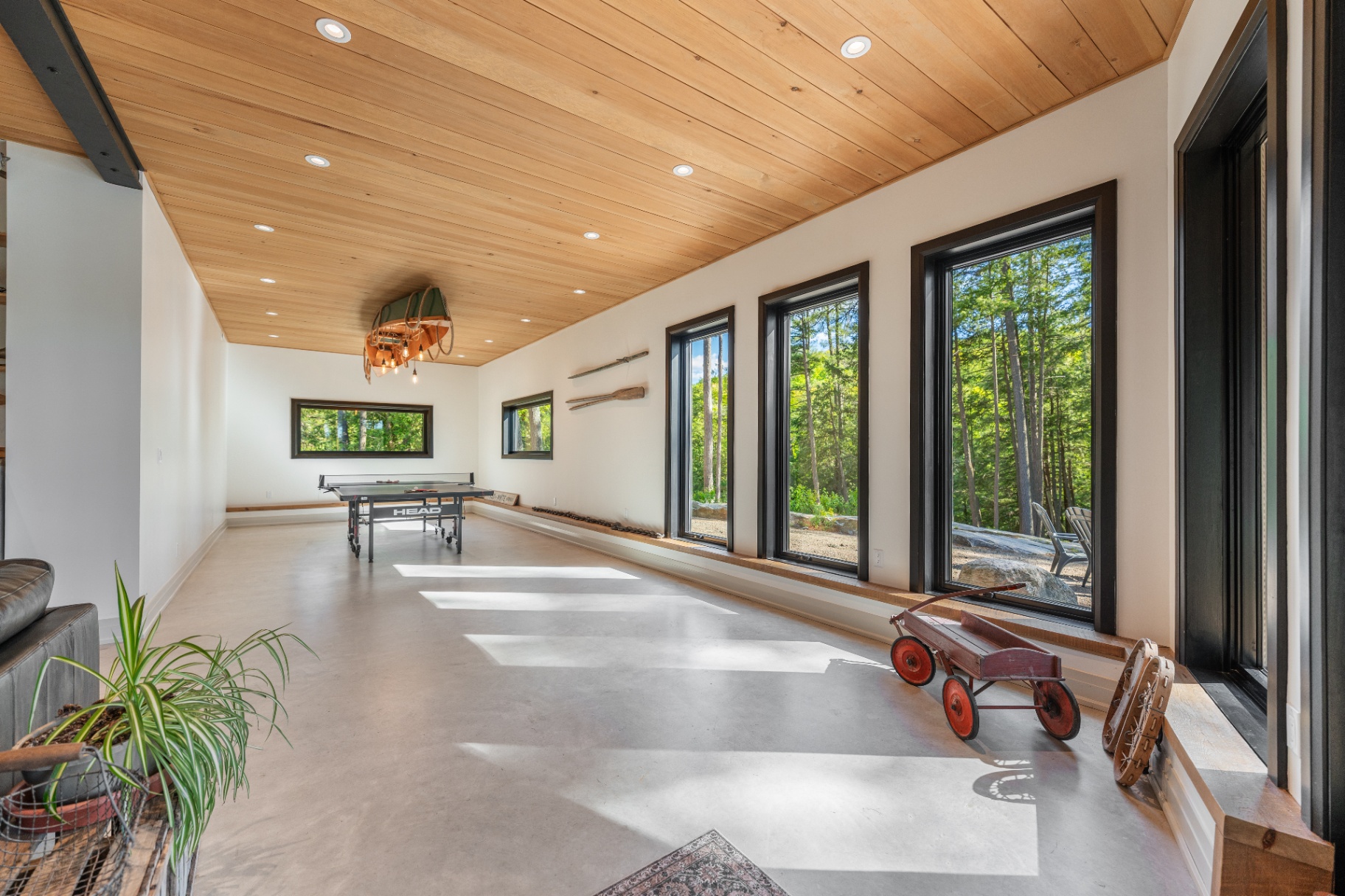 Games room with ping-pong table and wall of forest-view windows