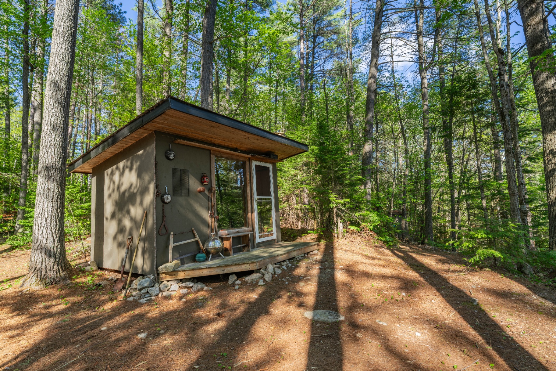 Closer view of the small woodland cabin with cedar trim