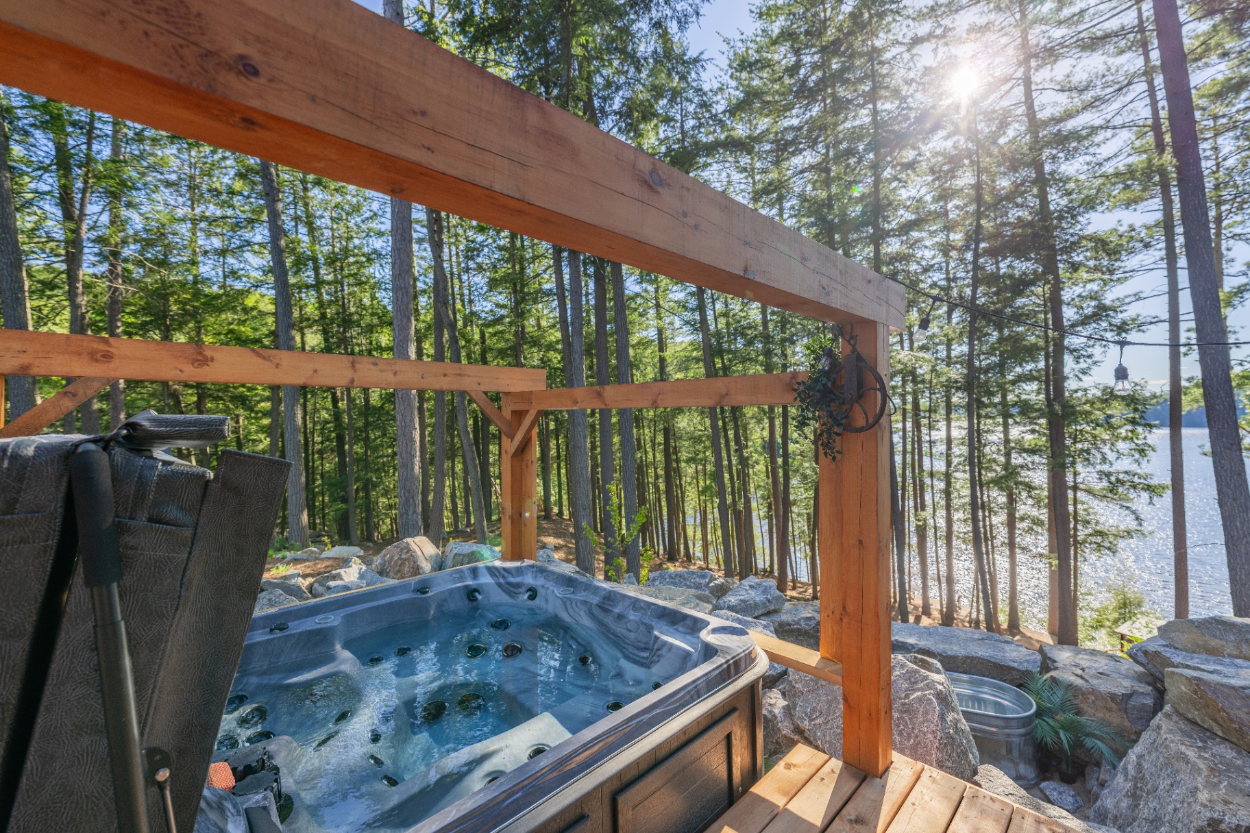 Hot tub terrace with timber pergola and lake view through the pines