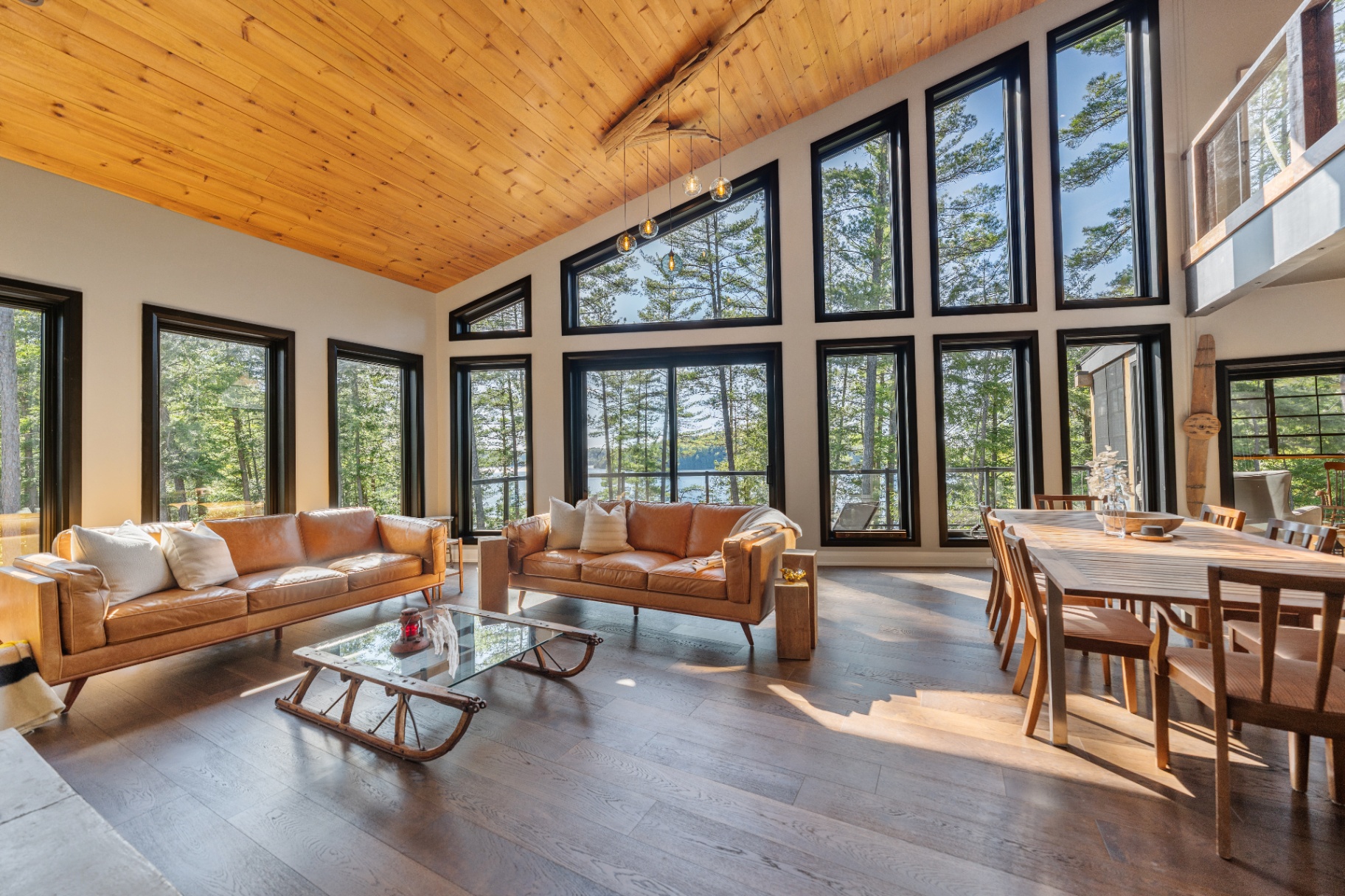Twin leather sofas beside the dining table under the vaulted ceiling