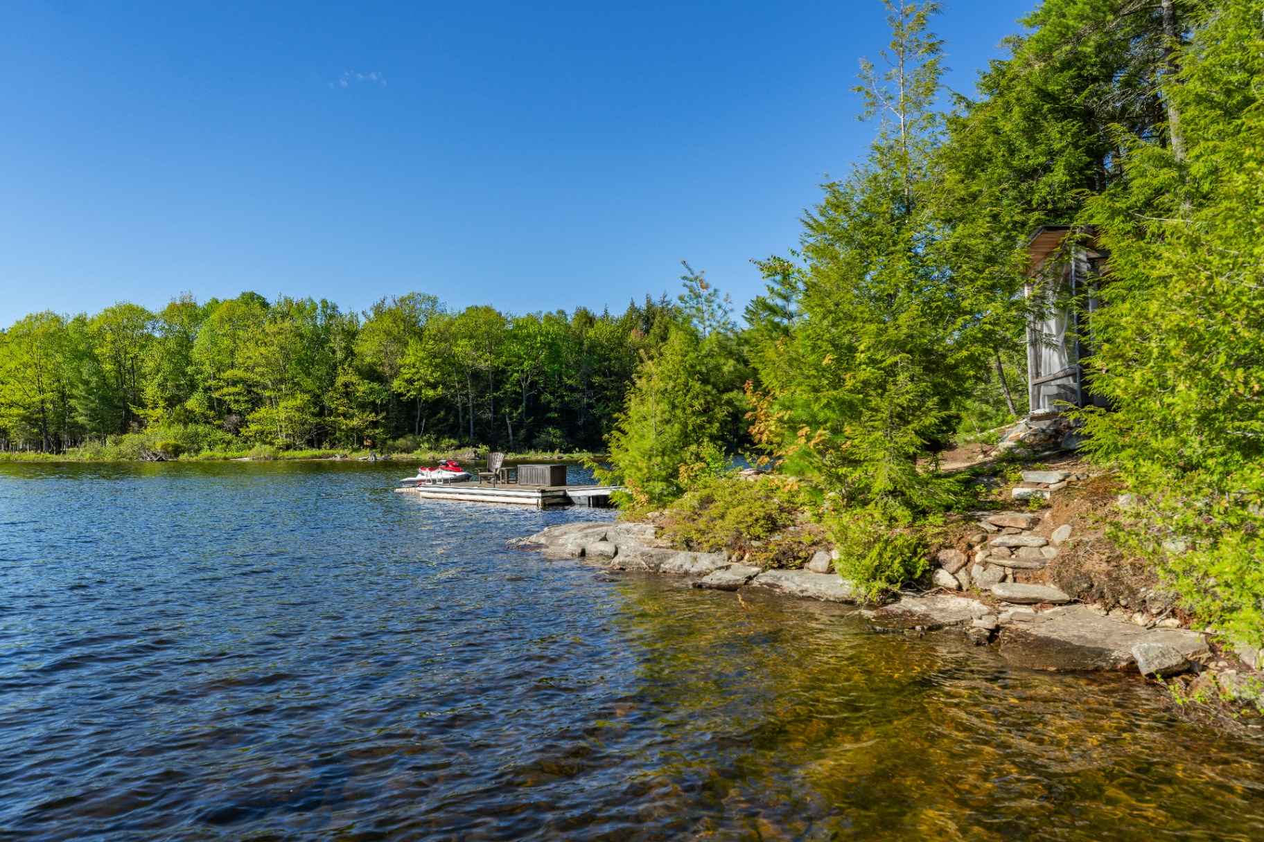 Stone-step path down to the second dock with jet ski and pine cover
