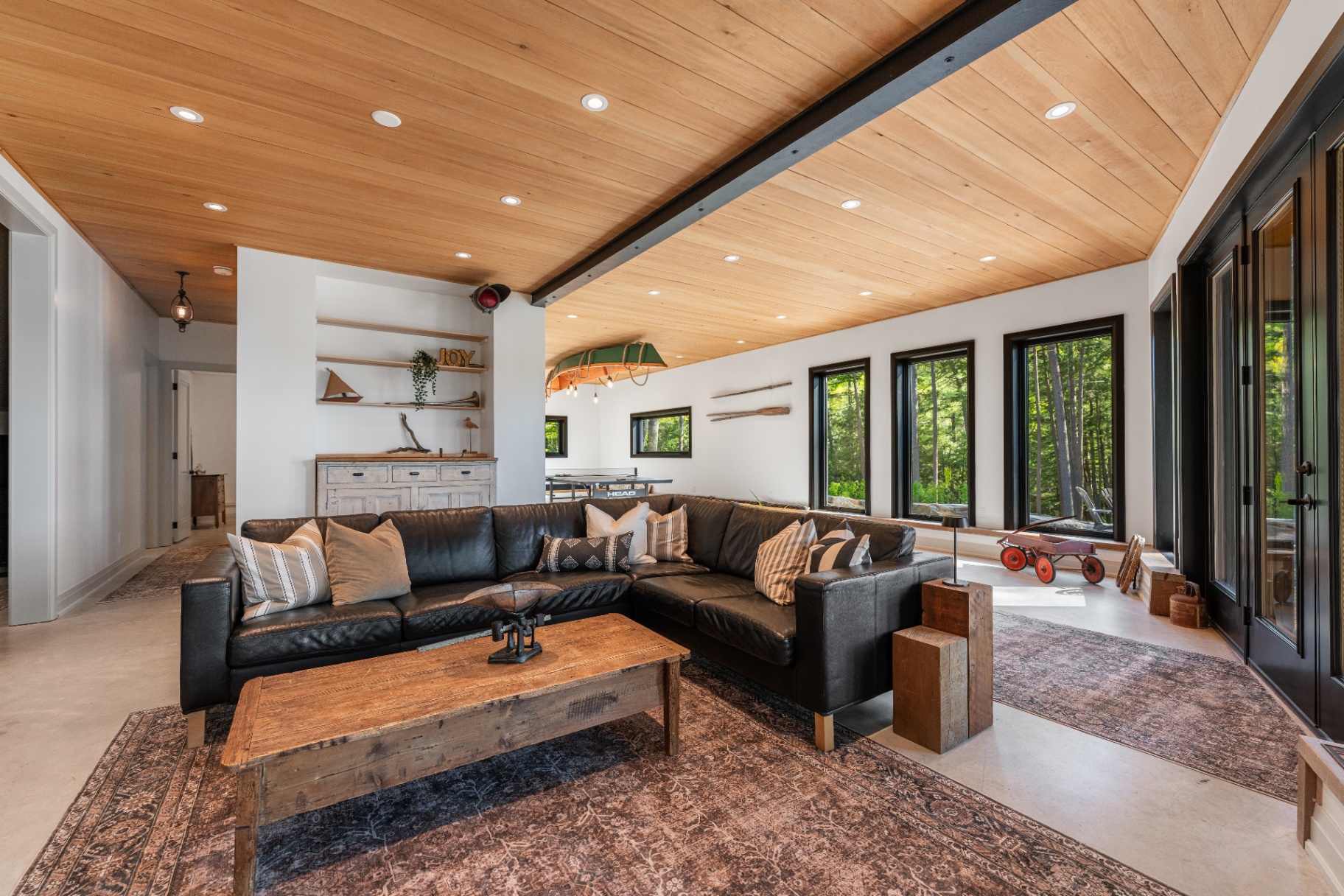 Family room with leather sectional, ping-pong table, and canoe light fixture