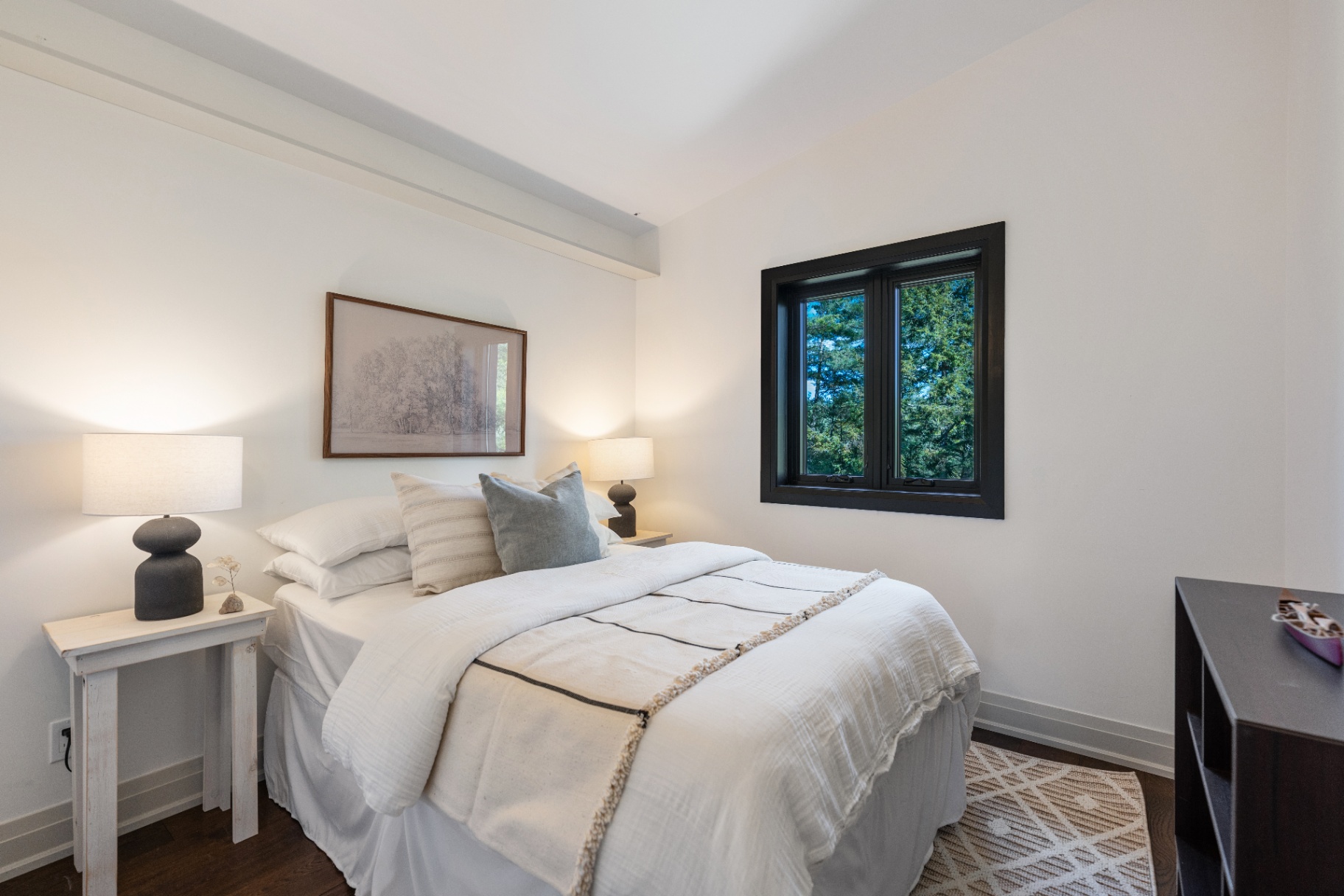 Guest bedroom with soft linens and framed artwork