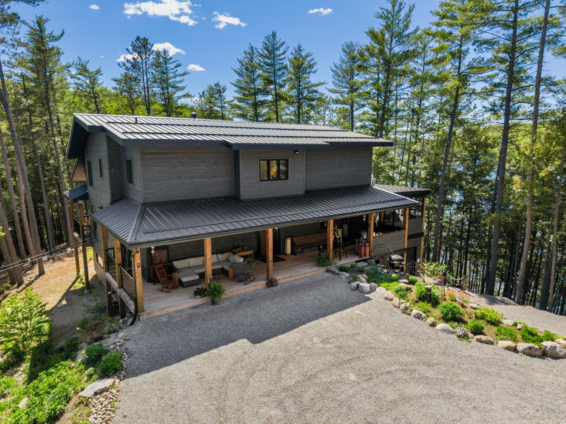 Aerial front view of the house with covered porch and winding drive